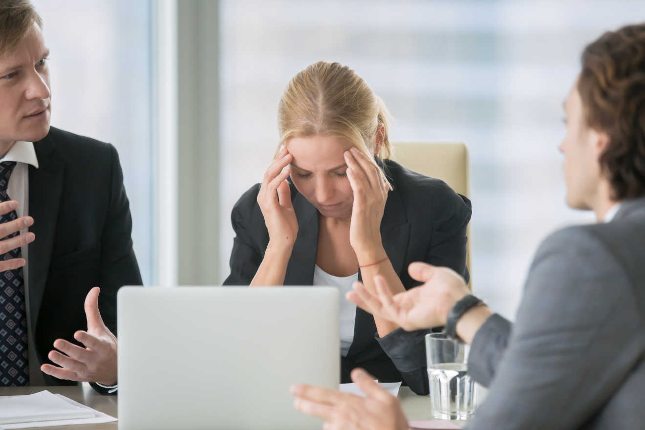 A woman at working looking stressed out  in a meeting